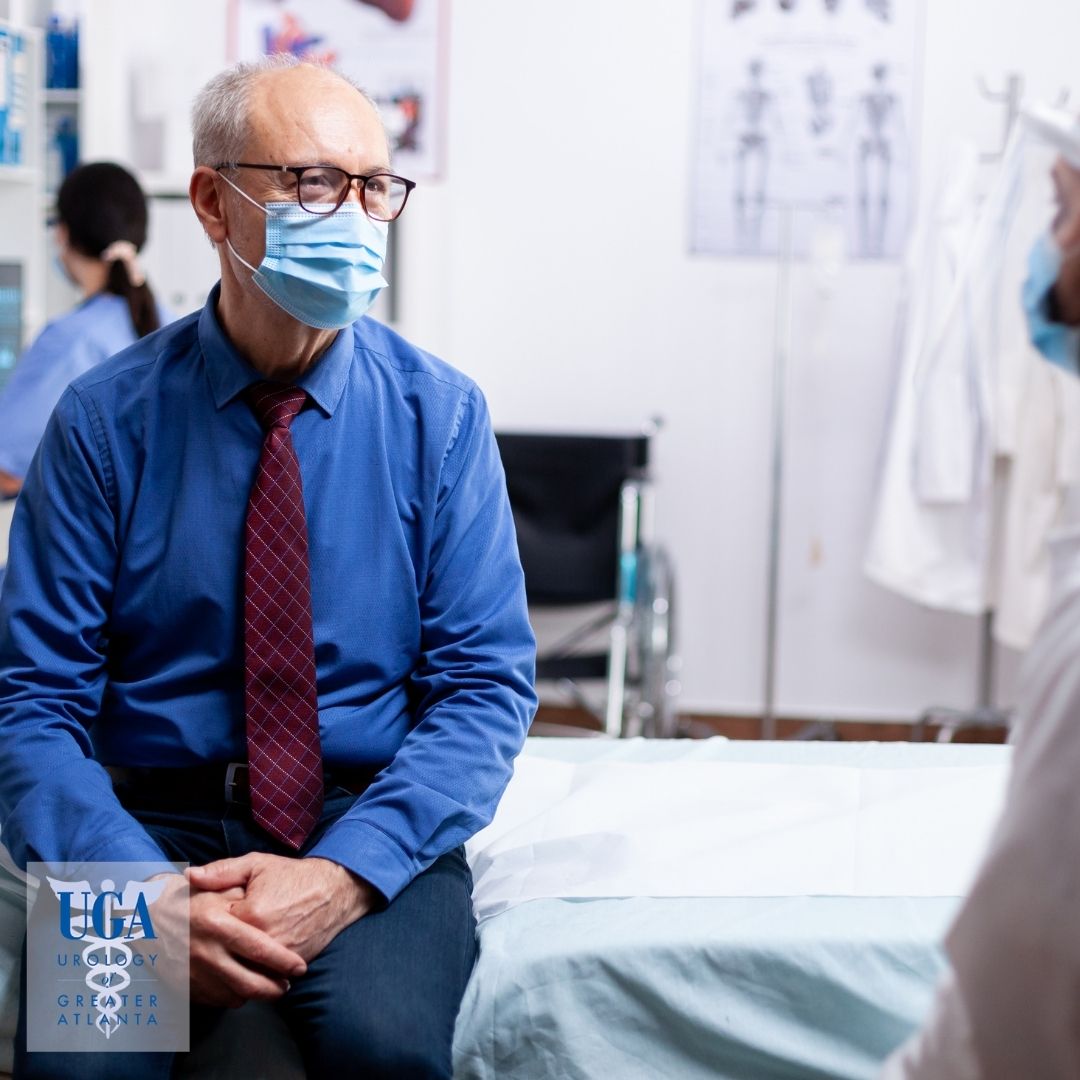 Older mna with mask talking to his doctor about changes in urine - Urology Of Greater Atlanta