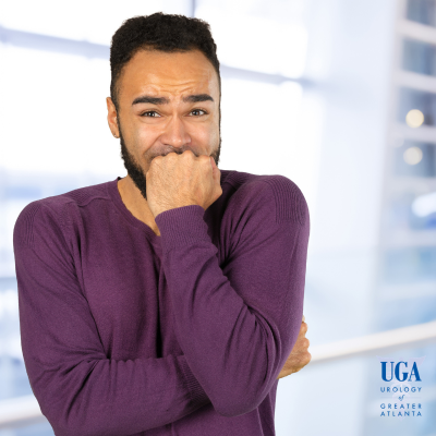 A man feeling uncomfortable at work having to urinate urgently.